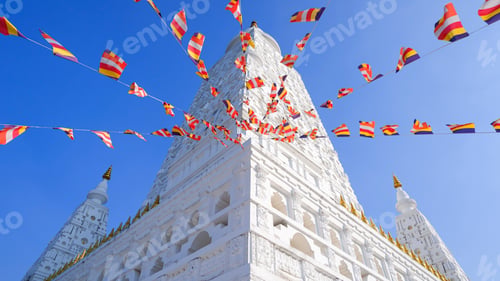 Preview: Ancient Thai Buddhist temple geometric architecture with colorful flags under clear blue sky.