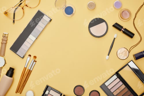 Preview: top view of necklace near decorative cosmetics isolated on yellow