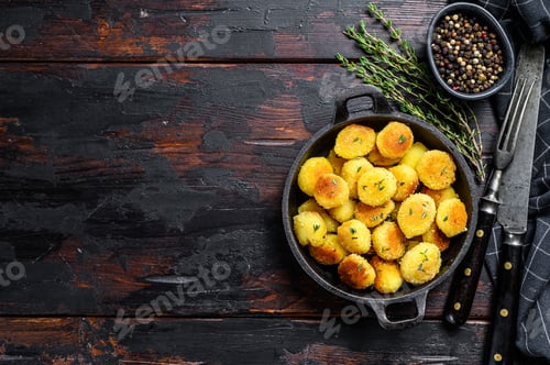 Preview: Fried gnocchi potato pasta. Black wooden background. Top view. Copy space