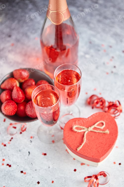 Preview: Bottle of rose champagne, glasses with fresh strawberries and heart shaped gift