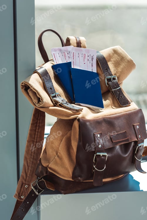 Preview: close up view of backpack, passports and tickets on airport windowsill