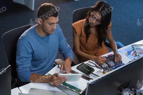 Preview: Computer engineers repairing motherboard at desk