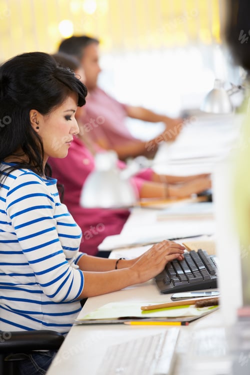 Preview: Woman Working At Desk In Busy Creative Office