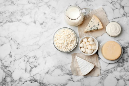 Preview: Different dairy products on light background, flat lay