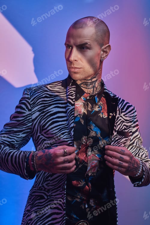 Preview: Fashionable tattooed male model posing in a studio