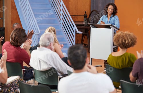 Preview: Woman At Podium Chairing Neighborhood Meeting In Community Centre
