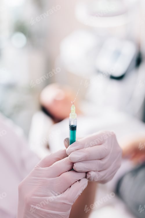 Preview: Aesthetic medicine doctor preparing syringe for injection