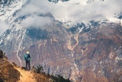 Preview: Young woman with backpack on the mountain peak