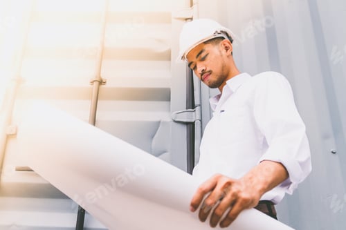 Preview: Civil engineer holding blueprint at the construction site.