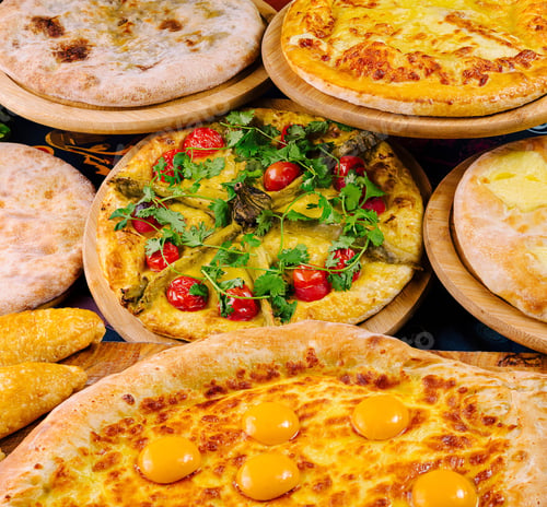 Preview: Various georgian dishes lying on wooden plates are waiting for customers in restaurant