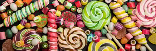 Preview: panoramic shot of bright round and swirl lollipops among fruit caramel candies