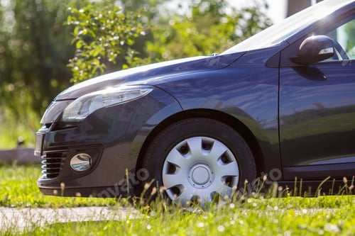 Preview: Close-up detail front of modern new shiny empty black car parked outside road