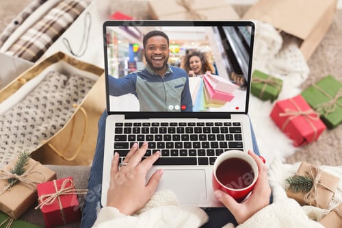 Preview: Black couple having video call with caucasian woman while shopping