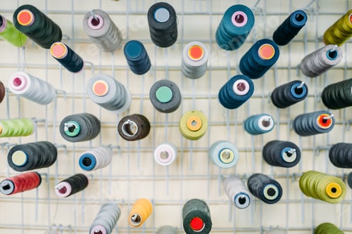 Preview: Colorful threads on spools closeup, side view