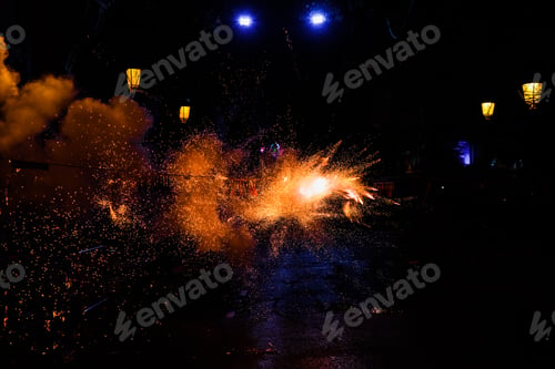 Preview: Sparks of colors in the night caused by the fire of a firecracker, black background.