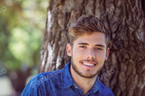 Preview: Handsome hipster smiling at camera on a sunny day