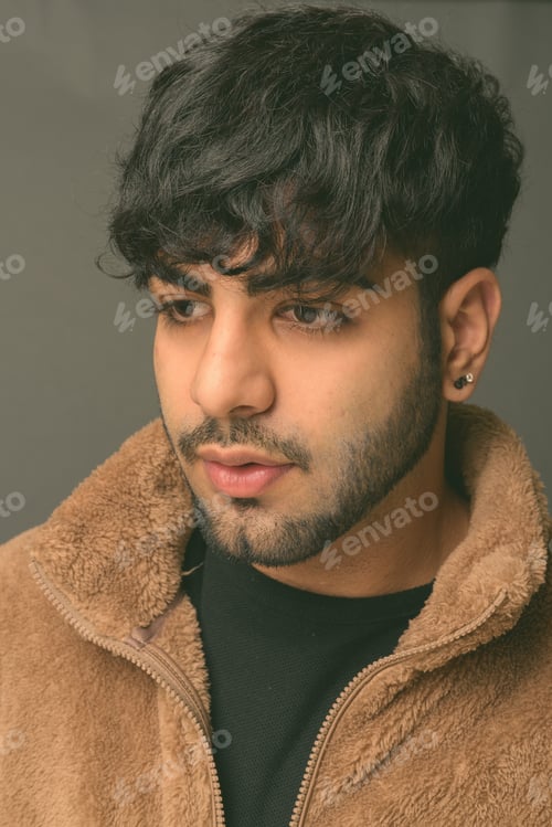 Preview: Young handsome Indian man against gray background