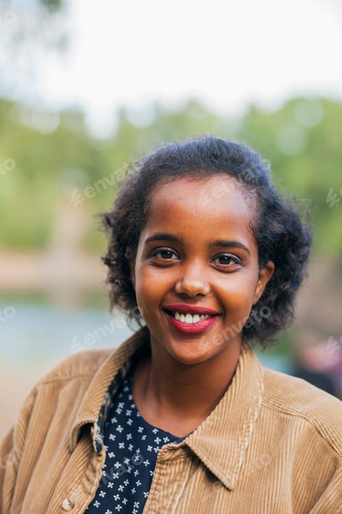 Preview: Portrait of happy young woman smiling outdoors