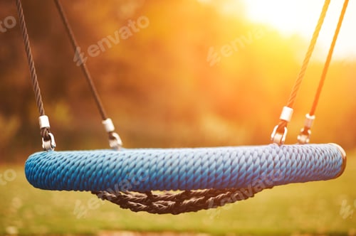 Preview: Empty children swing at sunset