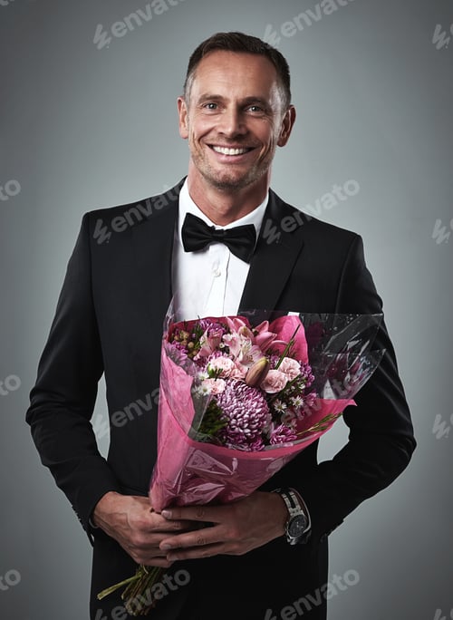 Preview: Courtship done right. Portrait of a well-dressed man holding a bouquet of flowers.