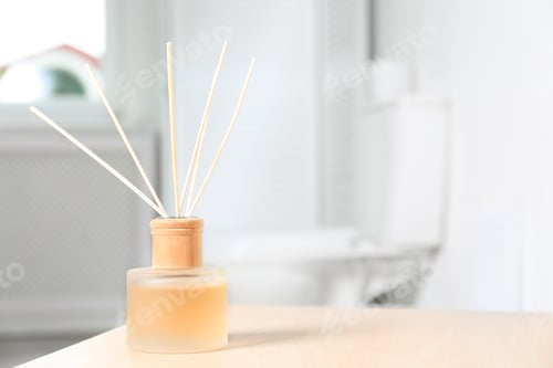 Preview: Reed air freshener with essential oils on table in bathroom. Space for text