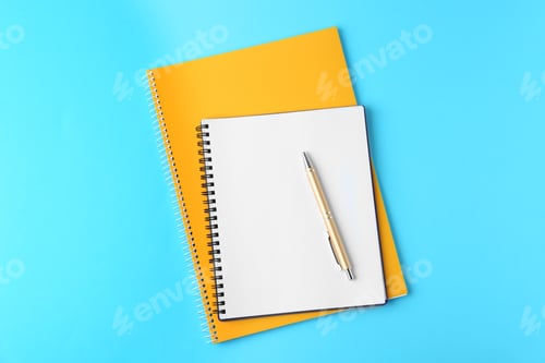 Preview: Notebooks and pen on light blue background, top view