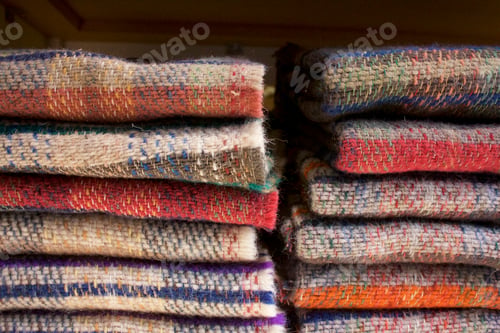 Preview: Stack of woolen tartan blankets or scarves for sale