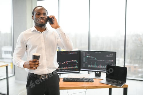 Preview: African-American broker works in office using workstation and analysis technology