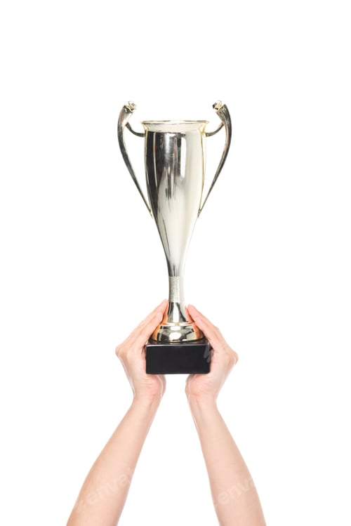 Preview: partial view of female hands holding champion cup isolated on white