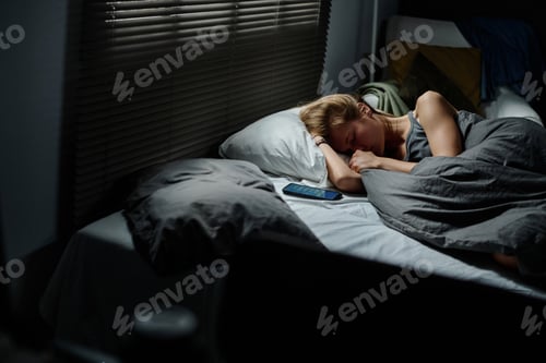 Preview: Unhappy and offended teenage girl keeping head on pillow and wiping tears