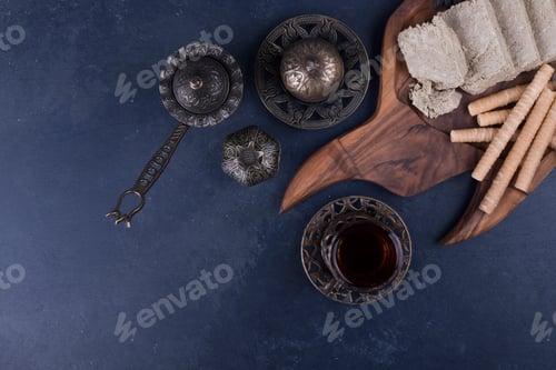 Preview: Caucasian halva sliced and served withwaffle sticks and a glass of tea