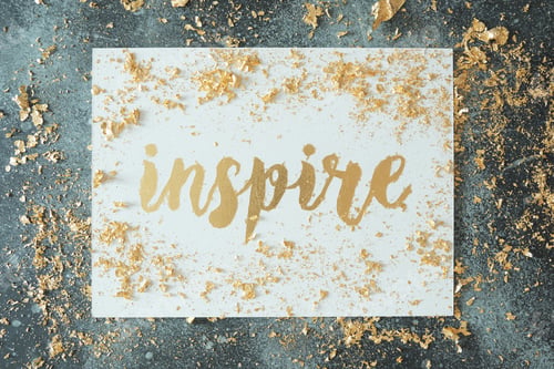 Preview: Inspire. Motivating lettering on white board. Handmade creativity. Gold letters. Gilding.