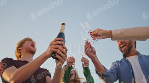 Preview: Man open splashing champagne at summer party close up. Excited guy pouring wine