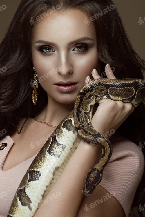 Preview: Beautiful girl brunette model, perfect curls and evening fashion make-up with a rabbit in her hands.