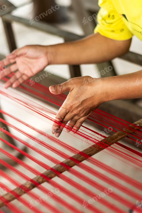 Preview: worker hands deyail with traditional natural silk making machine strings
