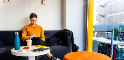 Preview: Middle aged business woman working with tablet from a cafe. Telework concept.
