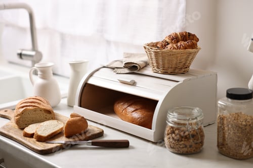 Preview: Wooden bread basket with freshly baked loaves on white marble table in kitchen