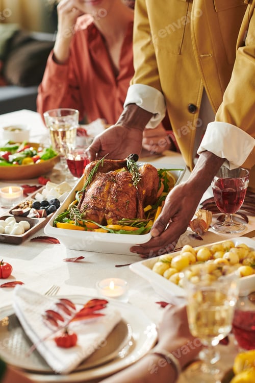Preview: Young Black Man Serving Roast Turkey during Thanksgiving Family Dinner Gathering