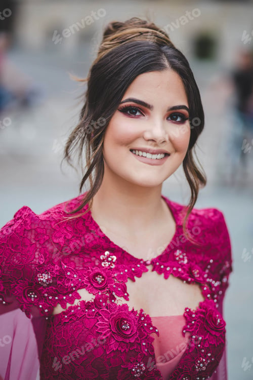 Preview: Shallow focus shot of a young beautiful Caucasian female in a pink dress posing at camera