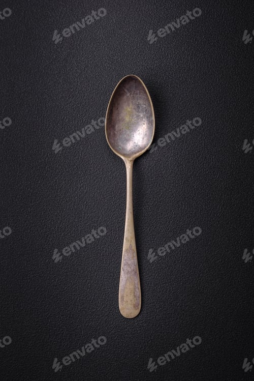 Preview: Empty metal spoon on dark textured concrete background