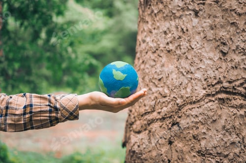 Preview: An Asian woman holds a globe in green forest,symbolizing importance preserving nature.emphasizes