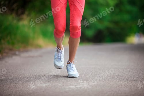 Preview: Cropped view of woman athlete running on pathway in park