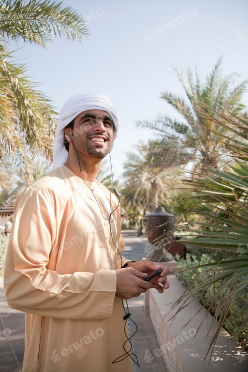 Vista previa: Hombre sonriente disfrutando de la música en un día soleado rodeado de palmeras