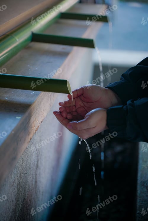 Preview: Vertical shot of a person washing hands before entering a temple