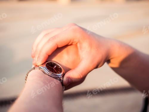 Preview: close up male hands checking time outdoors