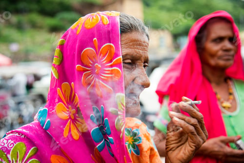 Preview: Old age woman smoking Indian handmade cigarette.