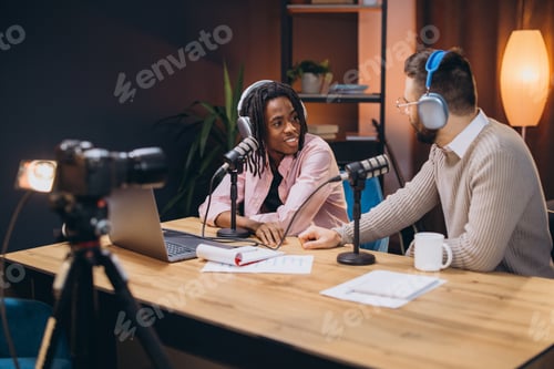 Preview: Two male podcasters talking during a live recording in a professional studio, using microphones