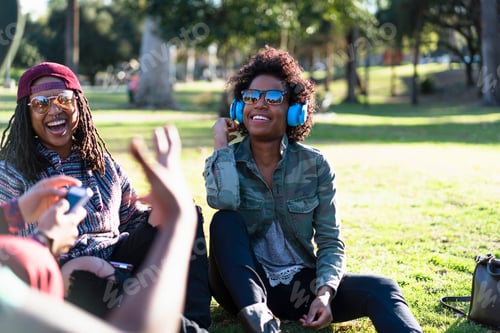 Preview: Group of female friends relaxing in park, laughing