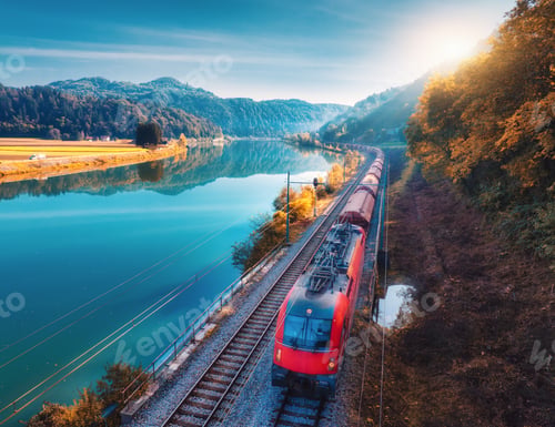 Preview: Aerial view of red high speed train moving near lake in mountains