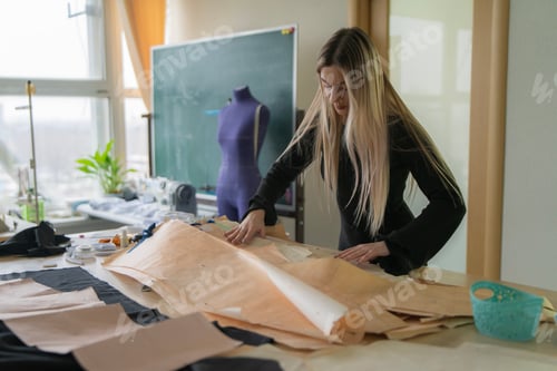 Preview: In a well-lit tailor studio, a skilled tailor examines pattern paper